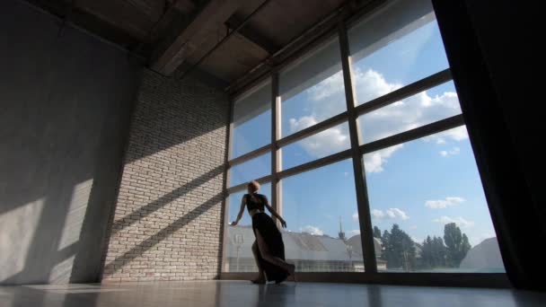 Indrukwekkend blond meisje dansen Contemporary in een venster bij zonsondergang in Studio in slo-mo — Stockvideo