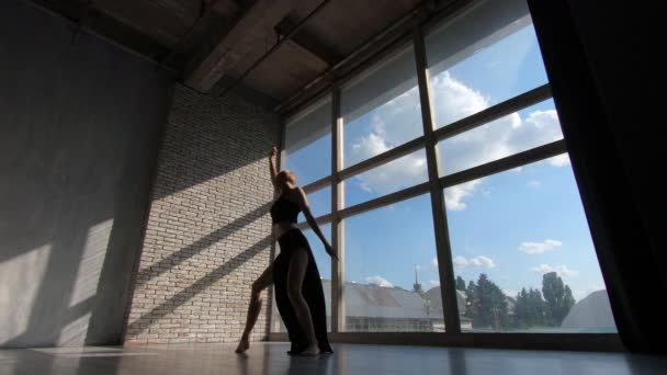 Ausdrucksstarkes blondes Mädchen, das zeitgenössische Performance an einem Fenster bei Sonnenuntergang im Studio in Slo-mo — Stockvideo