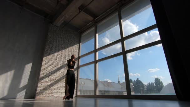 Linda menina loira dançando contemporânea em uma janela ao pôr do sol em estúdio em slo-mo — Vídeo de Stock