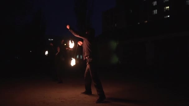 Jonglers femeninos y masculinos en trajes negros rotando bolas de fuego por la noche en slo-mo — Vídeos de Stock