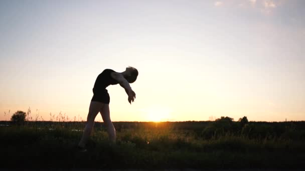 Cheery dziewczyna robi zaokrąglenie i Handstand z przodu Split o zachodzie słońca w SLO-mo — Wideo stockowe