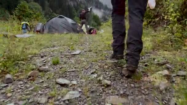Vue de l'arrière - Deux gars près des tentes dans la région montagneuse — Video