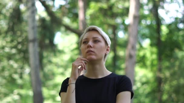 Благородная блондинка, стоящая и думающая о своей жизни в лесу в сло-мо — стоковое видео