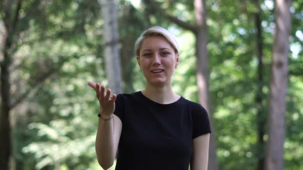 Mujer rubia alegre de pie y mostrando OK gesto al aire libre en slo-mo — Vídeos de Stock