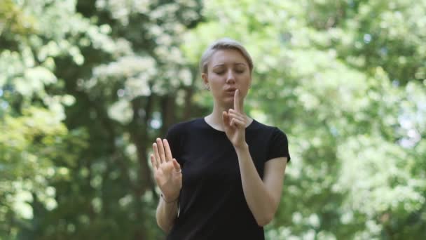 Mulher loira espiritual colocando seu dedo indicador antes de seus lábios em um beco em slo-mo — Vídeo de Stock