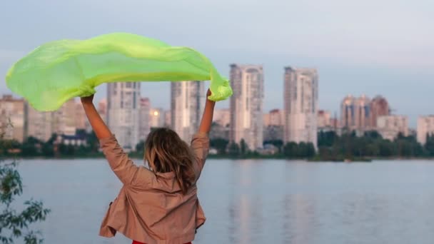 Mujer feliz de pie y agitando su pareo transparente en el gran lago al atardecer en slo-mo — Vídeos de Stock