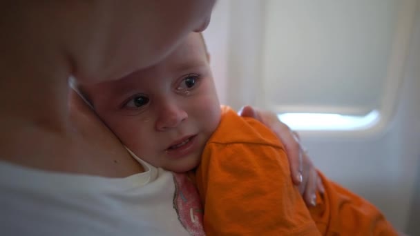 Uçakta küçük çocuk ağlıyor, anne yavaş çekimde onu sakinleştirir — Stok video