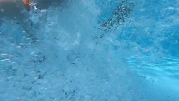 Ung brunett kille hoppar in i poolen, skytte med actionkamera — Stockvideo