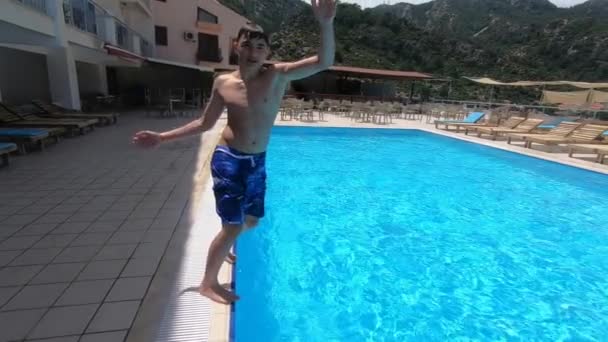 O menino faz um flip e mergulha na piscina em câmera lenta — Vídeo de Stock