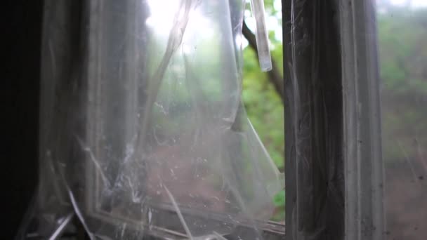 Oude gebroken venster met strepen van plastic fladderende langzaam in de zomer in slo-mo — Stockvideo