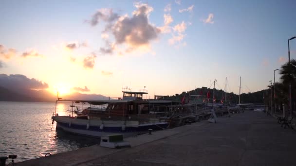 Un muelle con barcos en las montañas al atardecer en cámara lenta — Vídeo de stock