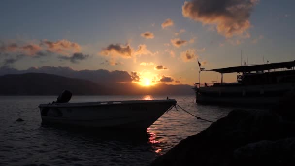 Barco amarrado contra el sol poniente en cámara lenta — Vídeos de Stock