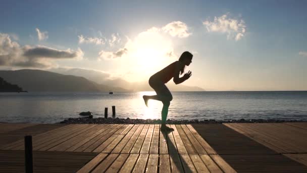 Meisje doet martial arts oefeningen, treinen op het strand bij zonsopgang in slow motion — Stockvideo