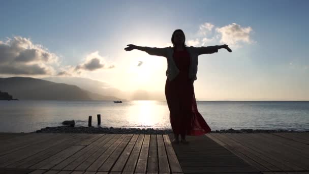 Yetişkin kadın yavaş hareket te gün doğumunda deniz kenarında ruhsal uygulama yapıyor — Stok video