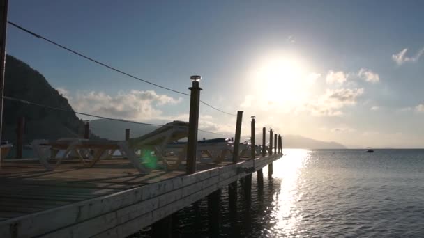 Wunderschöne Meereslandschaft, Ponton mit leeren Liegestühlen bei Sonnenaufgang in Zeitlupe — Stockvideo