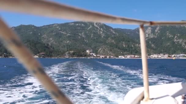 Żeglarstwo na łodzi od brzegu z pięknymi górami w zwolnionym tempie — Wideo stockowe