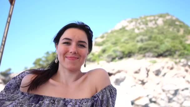 Mulher sorridente está em um barco em um vestido enquanto o barco está se movendo, câmera lenta — Vídeo de Stock