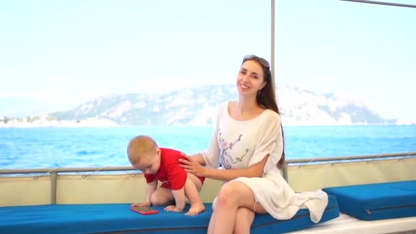 Young mother with her little son are sitting on the boat — Stock Video