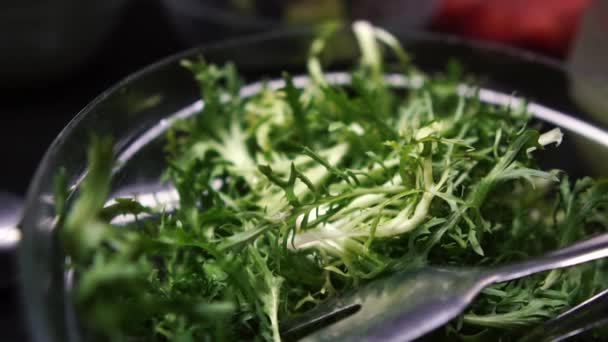 Green leaves in a bowl close up on a buffet in slow motion — Stock Video