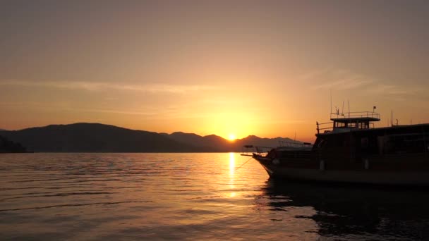 Increíble paisaje marino con un barco durante una puesta de sol dorada en cámara lenta — Vídeo de stock