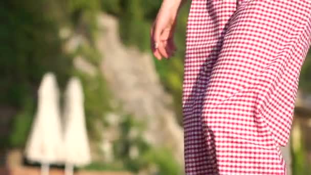 Vacker flicka går i höga klackar i snygga kläder i en semesterort i slow motion — Stockvideo