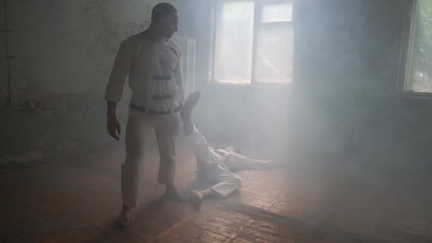 Een mentaal zieke man houdt de voet van de tweede psycho man in Raggy kamer in slo-mo — Stockvideo