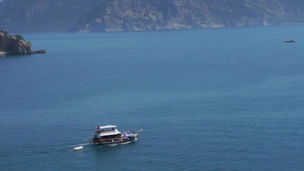 Bir tekne yavaş çekimde taş kayaların arasında körfezden dışarı yüzüyor — Stok video