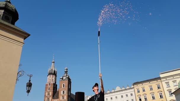 Cheery man stående och hålla en lång slang med fyrverkerier i Krakow på sommaren — Stockvideo