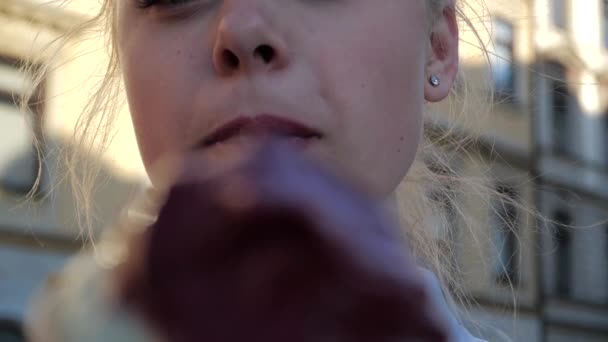 Smiling blonde girl licking herself and eating ice cream in Krakow in slo-mo — Stock Video