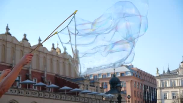 Hundratals färgglada tvål bubblor flyger över ett gammalt torg i Krakow på sommaren — Stockvideo