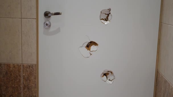Puerta blanca con agujeros de balas en un baño de hotel en Polonia — Vídeo de stock