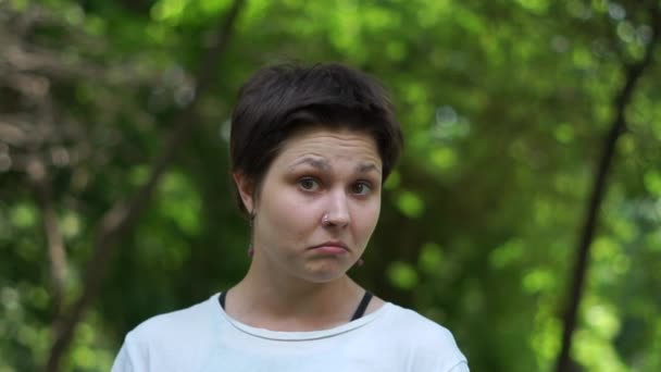 Lustige brünette Frau steht und sieht mit tiefer Überraschung in einem Wald in slo-mo — Stockvideo