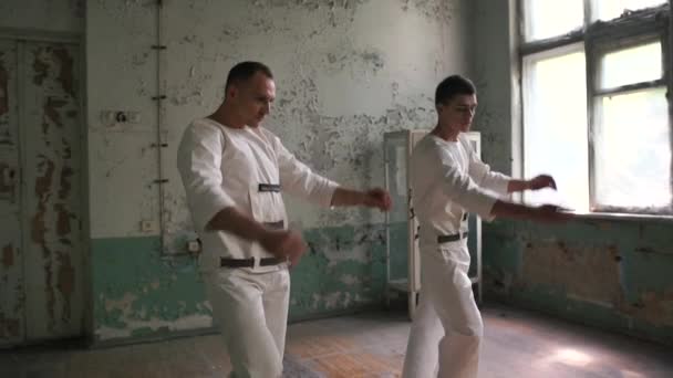 Двоє чоловіків-кухарів танцюють повільно і розмахують свої тіла навколо в залі в шлю-мо — стокове відео