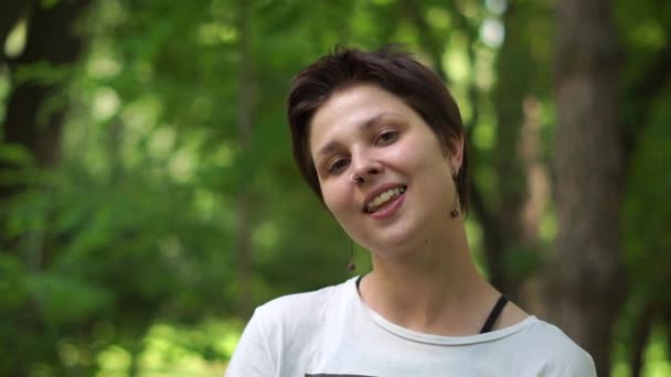 Romántica joven morena retozando y sonriendo en un bosque verde en slo-mo — Vídeos de Stock