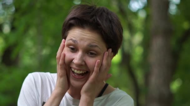 Allegro giovane donna bruna ridendo e tenendo la testa in mano in legno in slo-mo — Video Stock