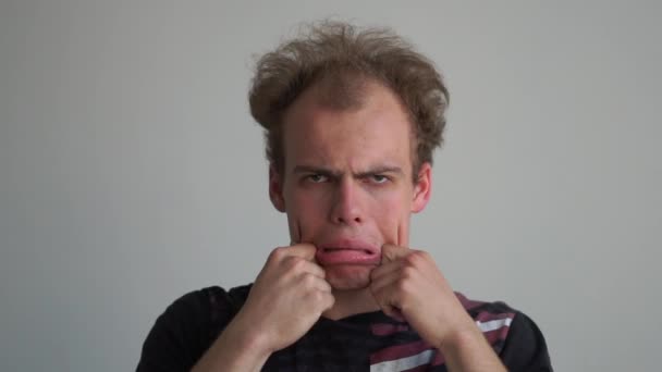 Homem cómico imitando e fazendo seus lábios grandes como um palhaço em um estúdio em slo-mo — Vídeo de Stock