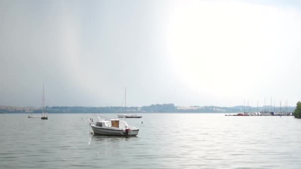 A small yacht sways on the water in cloudy weather — Stock Video