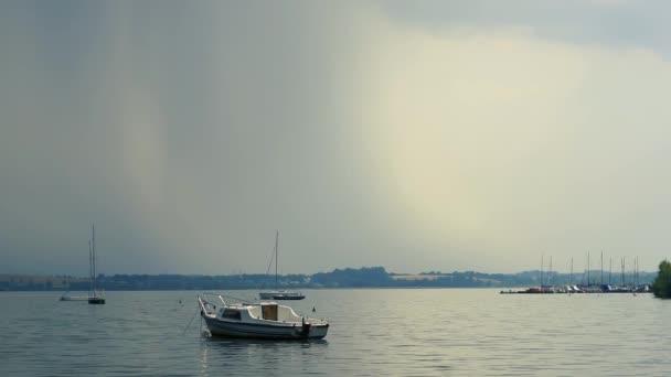 Mały jacht kołysze się po wodzie w pochmurnej pogodzie — Wideo stockowe