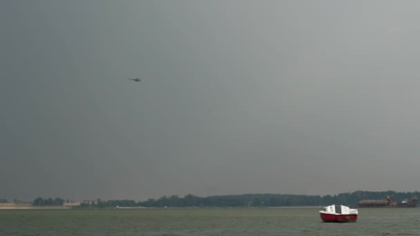 Un helicóptero vuela sobre el lago, y pequeñas embarcaciones en el lago — Vídeo de stock