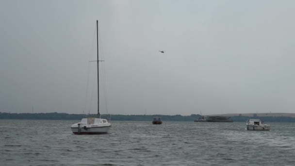 Un hélicoptère survole le lac, et de petits bateaux sur le lac — Video