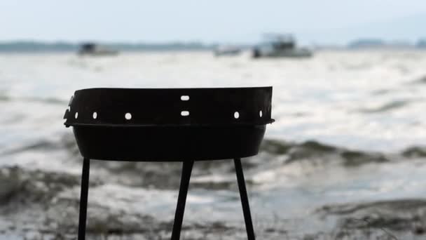 Empty barbecue on the lake near the trees during a storm — Stock Video