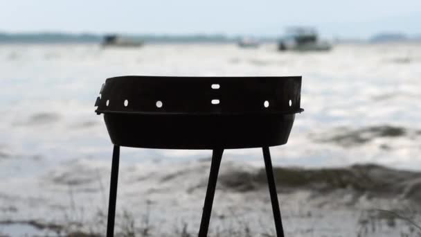 Empty barbecue on the lake near the trees during a storm - slow motion. — Stock Video