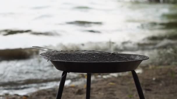 Empty barbecue on the lake during a storm - slow motion. — Stock Video