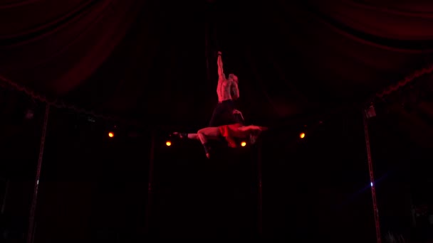 Manliga akrobat hålla en smal flicka gör en vertikal siffra på natten — Stockvideo