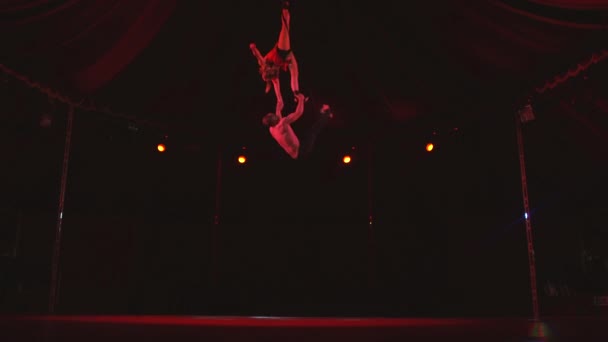 Mannelijke acrobaat houden meisjes been en hand draaien en verhuizen naar beneden 's nachts — Stockvideo