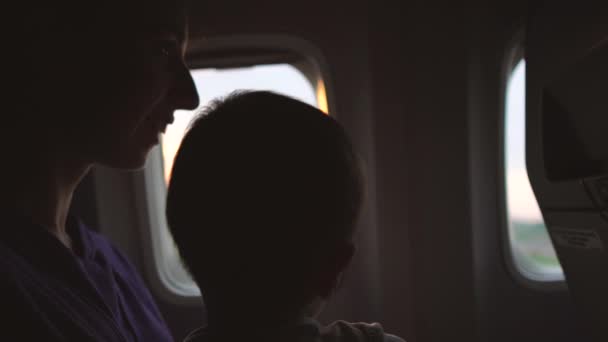 Çocuklu bir anne uçağın penceresinde otururken uçak havalanmaya başlar. — Stok video