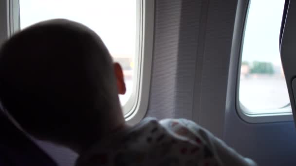 Madre con bambino vicino alla finestra dell'aereo si siede e aspetta il decollo . — Video Stock