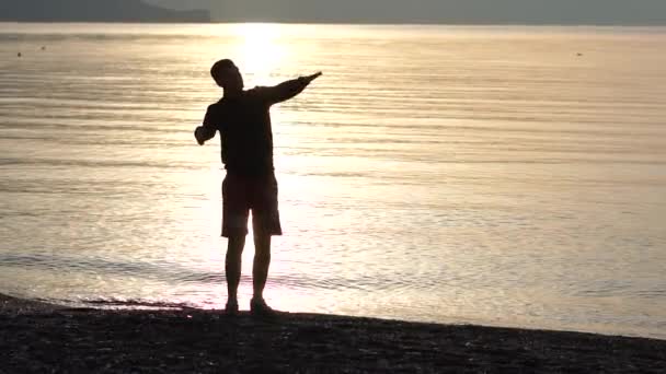 슬로우 모션으로 바다의 배경에 dab 팔 제스처를 만드는 사람 — 비디오