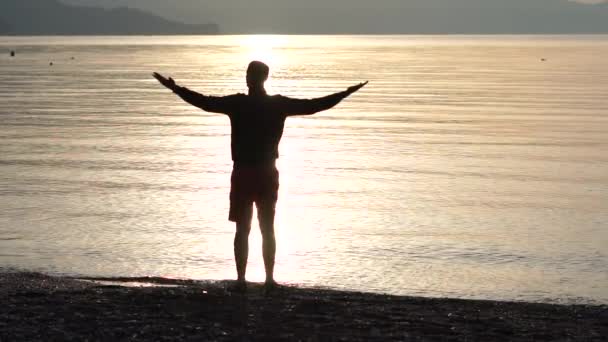 Man höjer händerna till solnedgången himmel, njuter av livet och naturen i slow motion — Stockvideo