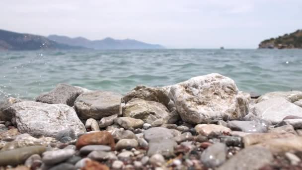 Meerwasser schlägt in Zeitlupe auf Küstensteine — Stockvideo